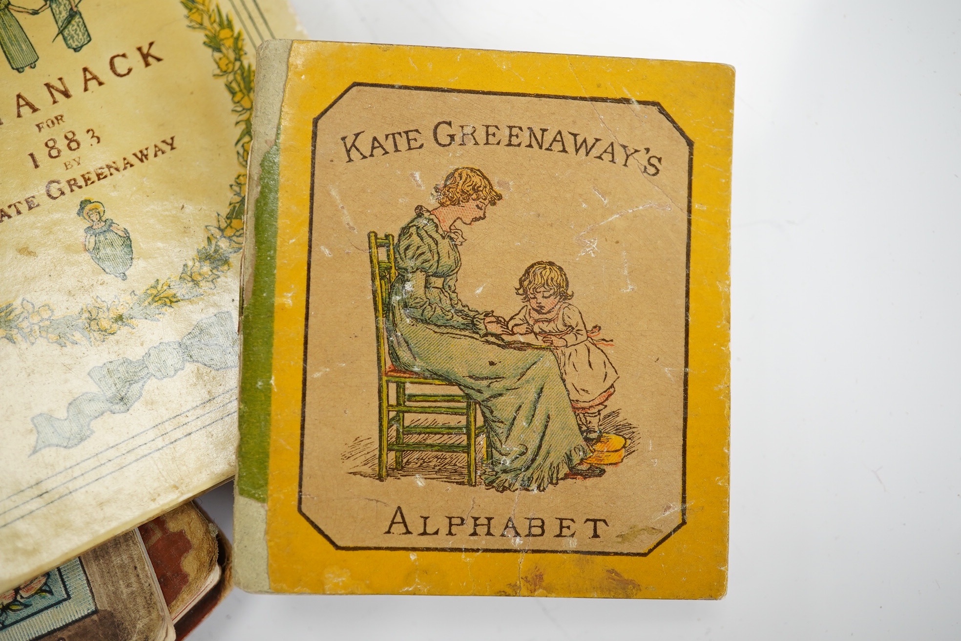 Greenaway, Kate - Kate Greenaway's Alphabet. coloured illus. throughout; original coloured pictorial boards, very sm. 8vo. (1885); Greenaway, Kate - Almanack for 1883. coloured illus.; original coloured pictorial boards,